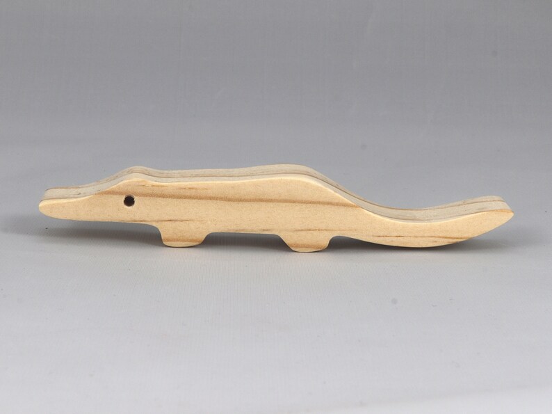 Handmade toy alligator cutout from the Itty Bitty Animal Collection. Crafted with traditional woodworking tools, this unfinished wood alligator is freestanding, smooth-sanded, and ready to paint. Perfect for stacking and imaginative play.