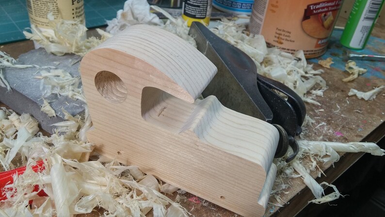 Odin' Toy Factory Toymakers Shop Photo - Handmade wooden toy car body under construction. Various tools are used to smooth and round the corners. There is lots of hand sanding.