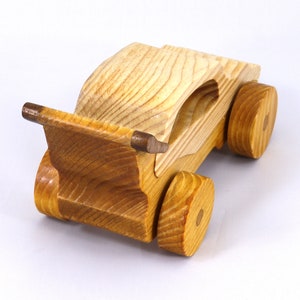 Handmade wooden toy car finished with nontoxic clear amber shellac and contrasting wood trim. Part of the Speedy Wheels Collection. Handcrafted in Tallahassee, Florida, USA. Length 5-1/2 inches, width 2-1/2 inches, height 2-1/2 inches. Made at Odin's Toy Factory.