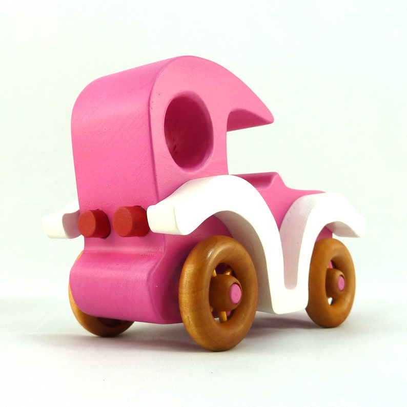 Handmade wooden toy car model-t sedan finished with hot pink and white acrylic paint with nonmaring amber shellac coated spoked wheels from my Bad Bob'S Custom Motors Collection.
