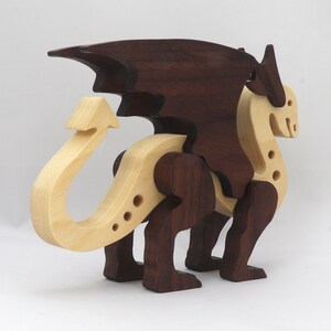 Handmade wooden dragon figurine made from contrasting hardwoods with a light natural wood body and head paired with rich dark reddish-brown wings, legs, and horns.