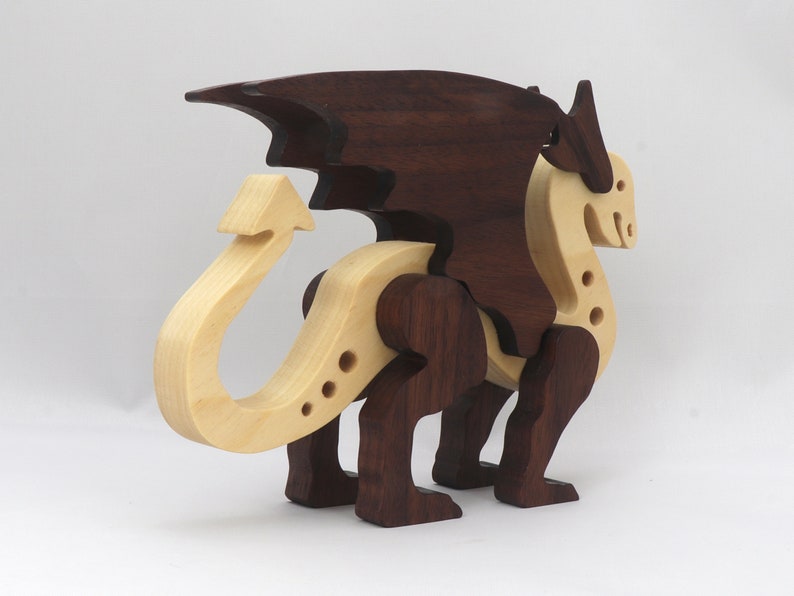 Handmade wooden dragon figurine made from contrasting hardwoods with a light natural wood body and head paired with rich dark reddish-brown wings, legs, and horns.