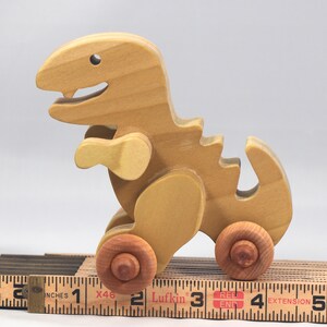 Handmade wooden push toy Tyrannosaurus Rex dinosaur made from select grade hardwoods and finished with a non-toxic coating.