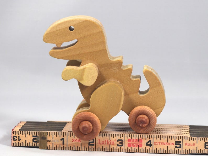 Handmade wooden push toy Tyrannosaurus Rex dinosaur made from select grade hardwoods and finished with a non-toxic coating.