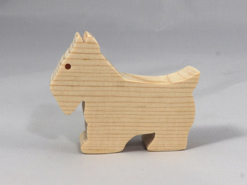 Handmade wood toy Scottie dog cutout unfinished unpainted paintable freestanding Itty Bitty Animal Collection. Approximate size 2.5 inches length by 2 inches height by 0.75 inches width. Handmade in Tallahassee Florida USA from natural wood offcuts.