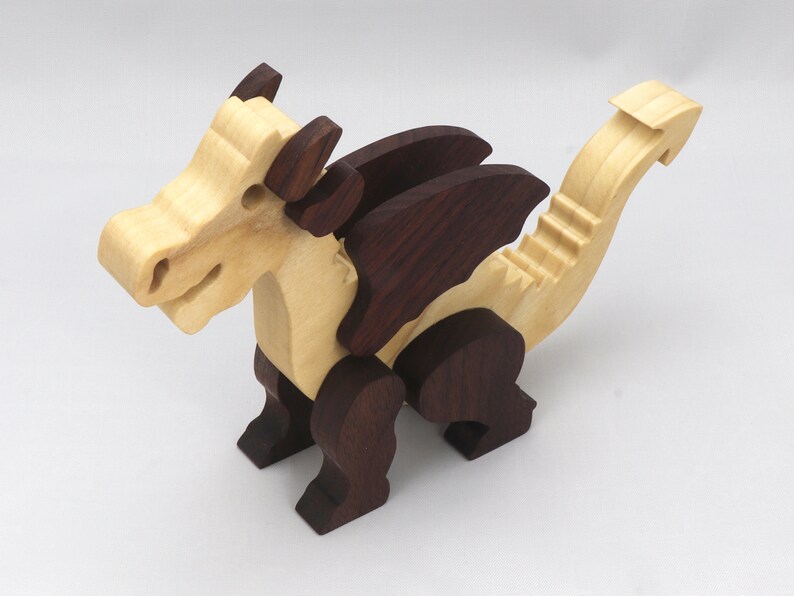 Wood Dragon Fantasy Animal Figurine is Handmade and finished with a renewable blend of mineral oil and waxes Applied hot for durabiliity and to enhance the beauty of the wood. There are ten dragons in this collection. A  link is in the description.