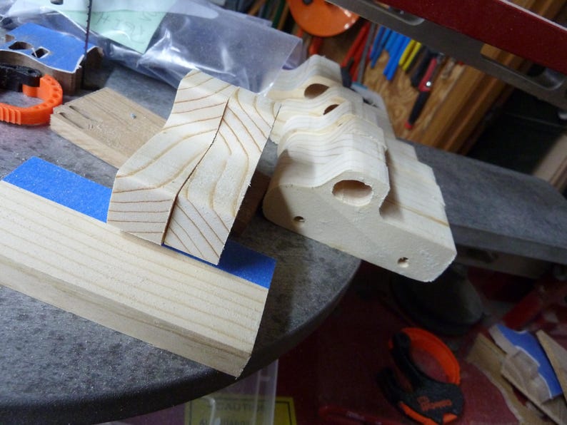 Wooden toy pickup truck bodies and cut wood pieces in my workshop, shown during construction before sanding and finishing.