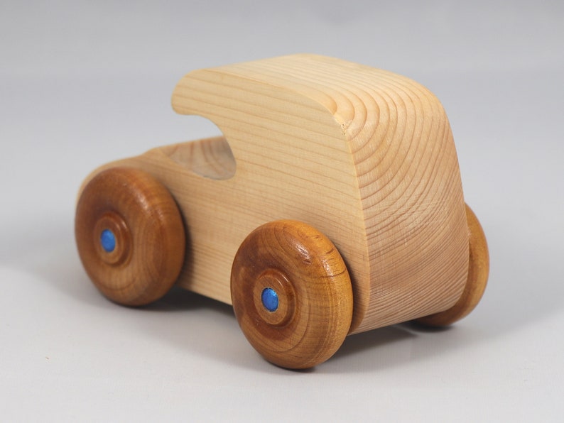 Handmade wooden toy car. The body is finished with clear shellac, and the wheels are finished with amber shellac. The hubs are painted with metallic sapphire blue trim.