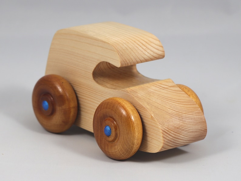Handmade wooden toy car. The body is finished with clear shellac, and the wheels are finished with amber shellac. The hubs are painted with metallic sapphire blue trim.