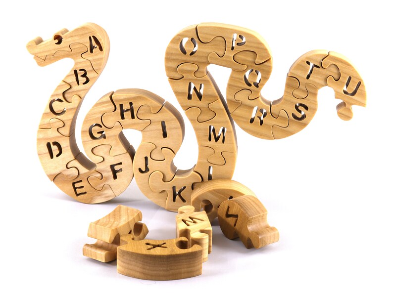 Hand-cut Alphabet Snake Puzzle made from premium hardwood, finished with mineral oil and beeswax for durability. Each of the 26 pieces represents a letter, promoting alphabet learning and essential skills development in kids through play.