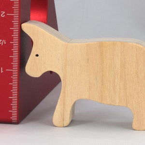 A handmade and unfinished wooden toy cow cutout is perfect for those who love to paint and customize their toys. It is freestanding and stackable, making it a versatile addition to any playroom or nursery. From My Itty Bitty Animal Collection.