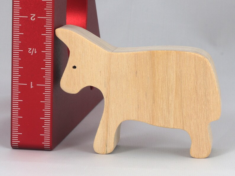 A handmade and unfinished wooden toy cow cutout is perfect for those who love to paint and customize their toys. It is freestanding and stackable, making it a versatile addition to any playroom or nursery. From My Itty Bitty Animal Collection.
