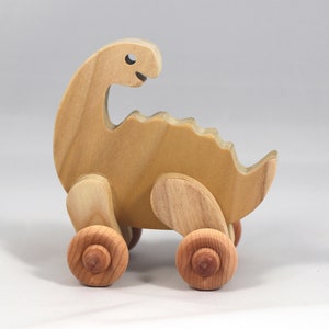 Handmade wooden push toy dinosaur made from select grade hardwoods and finished with a non-toxic coating.