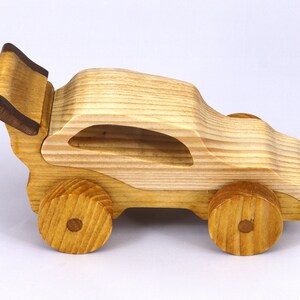 Handmade wooden toy car finished with nontoxic clear amber shellac and contrasting wood trim. Part of the Speedy Wheels Collection. Handcrafted in Tallahassee, Florida, USA. Length 5-1/2 inches, width 2-1/2 inches, height 2-1/2 inches. Made at Odin's Toy Factory.