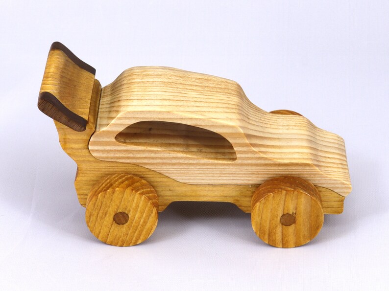 Handmade wooden toy car finished with nontoxic clear amber shellac and contrasting wood trim. Part of the Speedy Wheels Collection. Handcrafted in Tallahassee, Florida, USA. Length 5-1/2 inches, width 2-1/2 inches, height 2-1/2 inches. Made at Odin's Toy Factory.