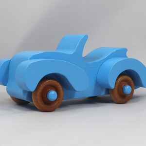 Handmade painted wooden toy car, baby blue convertible with fat fendered roadster design. Non-marring wheels finished with amber shellac.