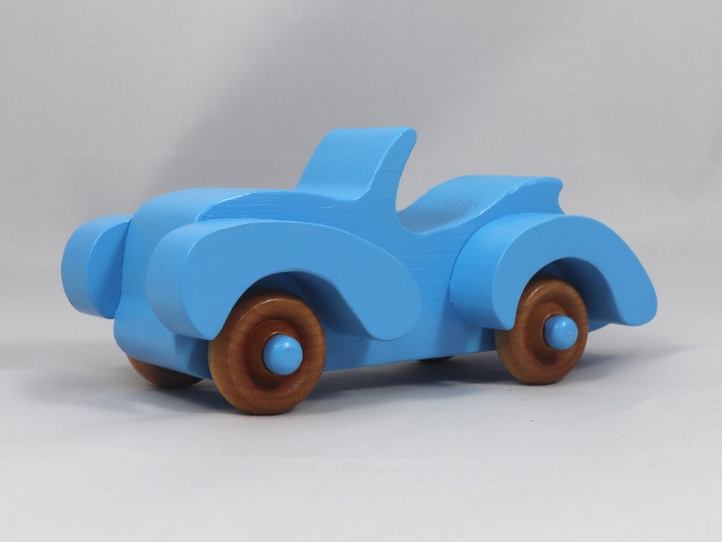 Handmade painted wooden toy car, baby blue convertible with fat fendered roadster design. Non-marring wheels finished with amber shellac.