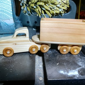 Handmade wooden toy tractor trailer semi truck finished with clear shellac. Crafted from natural wood using traditional woodworking tools. Approximate size 7 inches long. Made in Tallahassee, Florida, USA from Odin's Toy Factory Play Pal Collection.