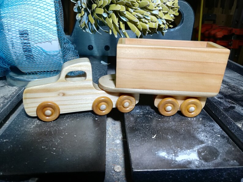Handmade wooden toy tractor trailer semi truck finished with clear shellac. Crafted from natural wood using traditional woodworking tools. Approximate size 7 inches long. Made in Tallahassee, Florida, USA from Odin's Toy Factory Play Pal Collection.