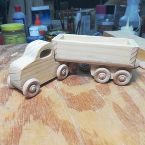 Handmade wooden toy tractor trailer semi truck finished with clear shellac. Crafted from natural wood using traditional woodworking tools. Approximate size 7 inches long. Made in Tallahassee, Florida, USA from Odin's Toy Factory Play Pal Collection.