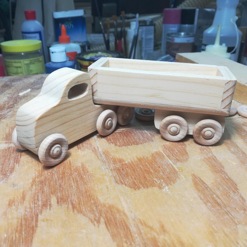 Handmade wooden toy tractor trailer semi truck finished with clear shellac. Crafted from natural wood using traditional woodworking tools. Approximate size 7 inches long. Made in Tallahassee, Florida, USA from Odin's Toy Factory Play Pal Collection.
