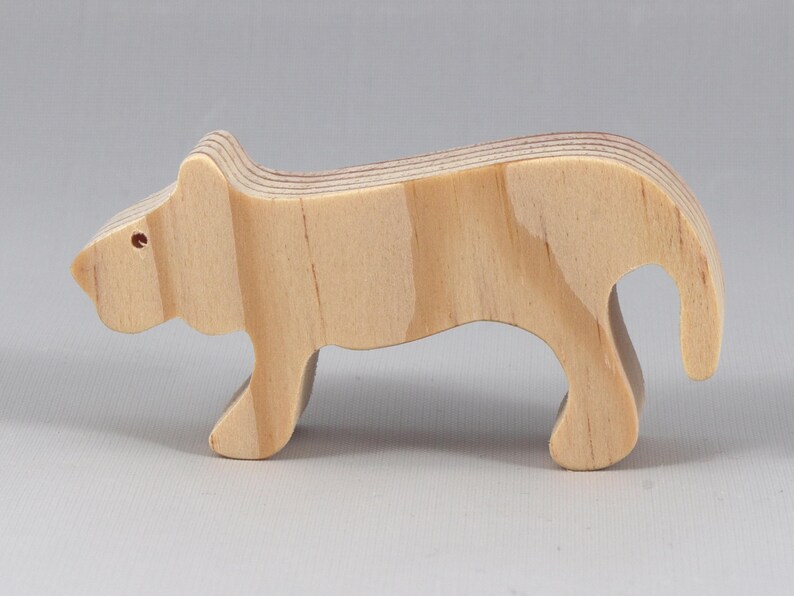 This is an unfinished wooden lioness cutout from solid wood using traditional woodworking techniques. Sanded smooth and ready to paint, stain, or customize. Freestanding design for small hands, toddlers, young children, crafters, collectors, and display. I take custom orders for any animal, quantity, and mix — including large ornament orders. Mix and match, request a different size, or send a drawing or pattern. Handmade by Odin's Toy Factory in Tallahassee, Florida, USA.