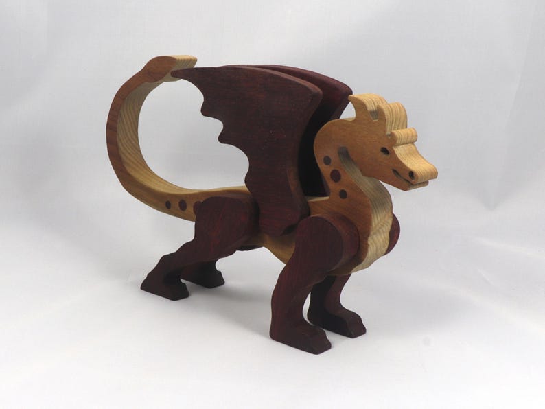 Handmade wooden dragon figurine made from contrasting hardwoods with a light natural wood body and head paired with rich dark reddish-brown wings, legs, and horns.