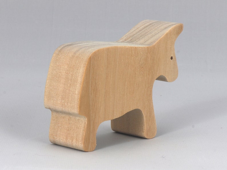 A handmade and unfinished wooden toy cow cutout is perfect for those who love to paint and customize their toys. It is freestanding and stackable, making it a versatile addition to any playroom or nursery. From My Itty Bitty Animal Collection.