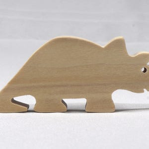 This is an unfinished wooden Wooden Toy Dinosaur Triceratops cutout from solid wood using traditional woodworking techniques. Sanded smooth and ready to paint, stain, or customize. Freestanding design for small hands, toddlers, young children, crafters, collectors, and display. I take custom orders for any animal, quantity, and mix — including large ornament orders. Mix and match, request a different size, or send a drawing or pattern. Handmade by Odin's Toy Factory in Tallahassee, Florida, USA.