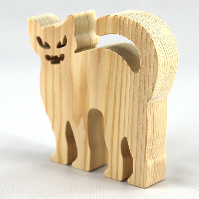 Handmade unfinished wooden Halloween cat cutout by Odin's Toy Factory. Freestanding cat figure cut from 3/4 inch thick wood and ready to paint. Approximate size 3.5 inches height by 3.5 inches width by 0.75 inches thick. Hand-cut solid wood Halloween decoration for crafts, toys, ornaments, and display. Custom orders available. Made in Tallahassee, Florida, USA.