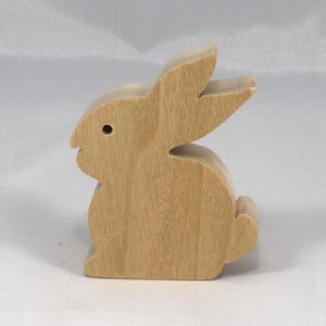 This is an unfinished wooden Rabbit cutout from solid wood using traditional woodworking techniques. Sanded smooth and ready to paint, stain, or customize. Freestanding design for small hands, toddlers, young children, crafters, collectors, and display. I take custom orders for any animal, quantity, and mix — including large ornament orders. Mix and match, request a different size, or send a drawing or pattern. Handmade by Odin's Toy Factory in Tallahassee, Florida, USA.