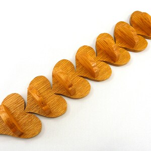 Handmade heart-shaped shelf crafted from reclaimed oak hardwood and finished with polyurethane. Perfect for displaying small items and adding rustic charm to home decor.