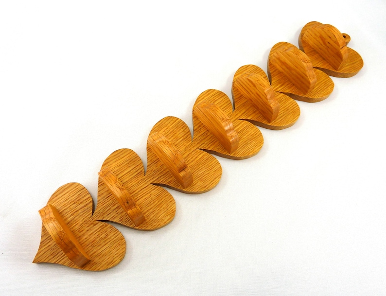 Handmade heart-shaped shelf crafted from reclaimed oak hardwood and finished with polyurethane. Perfect for displaying small items and adding rustic charm to home decor.