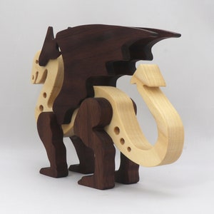 Handmade wooden dragon figurine made from contrasting hardwoods with a light natural wood body and head paired with rich dark reddish-brown wings, legs, and horns.