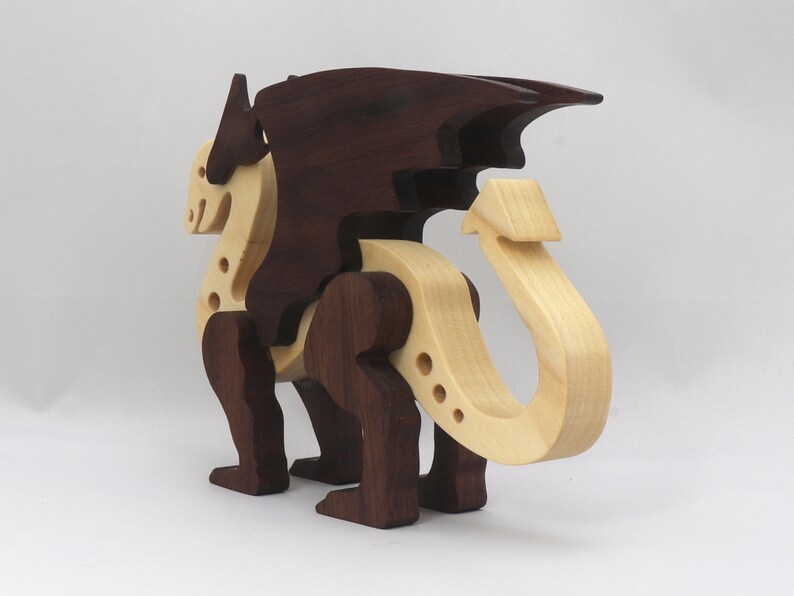 Handmade wooden dragon figurine made from contrasting hardwoods with a light natural wood body and head paired with rich dark reddish-brown wings, legs, and horns.