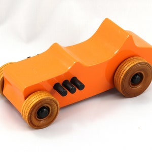 Handmade wooden toy car modeled after a 1927 T-Bucket hot rod. Finished with orange and black acrylic paint and amber shellac.