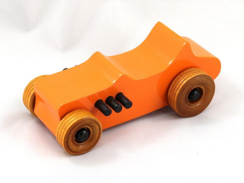 Handmade wooden toy car modeled after a 1927 T-Bucket hot rod. Finished with orange and black acrylic paint and amber shellac.