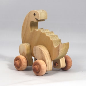Handmade wooden push toy dinosaur made from select grade hardwoods and finished with a non-toxic coating.