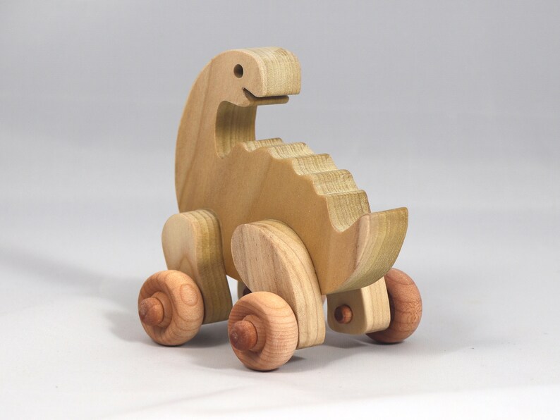 Handmade wooden push toy dinosaur made from select grade hardwoods and finished with a non-toxic coating.