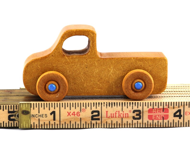 This handmade toy pickup truck from My Play Pal Collection is finished with amber shellac and metallic sapphire blue acrylic paint. It is just one of many unique wooden vehicles available.