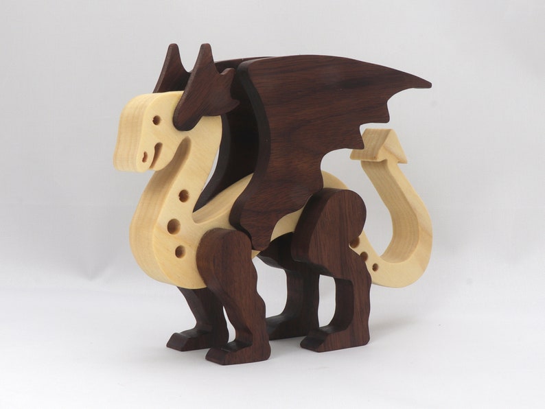 Handmade wooden dragon figurine made from contrasting hardwoods with a light natural wood body and head paired with rich dark reddish-brown wings, legs, and horns.