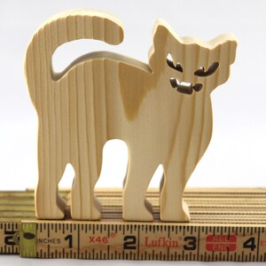 Handmade unfinished wooden Halloween cat cutout by Odin's Toy Factory. Freestanding cat figure cut from 3/4 inch thick wood and ready to paint. Approximate size 3.5 inches height by 3.5 inches width by 0.75 inches thick. Hand-cut solid wood Halloween decoration for crafts, toys, ornaments, and display. Custom orders available. Made in Tallahassee, Florida, USA.