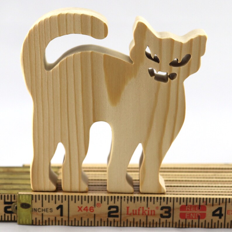 Handmade unfinished wooden Halloween cat cutout by Odin's Toy Factory. Freestanding cat figure cut from 3/4 inch thick wood and ready to paint. Approximate size 3.5 inches height by 3.5 inches width by 0.75 inches thick. Hand-cut solid wood Halloween decoration for crafts, toys, ornaments, and display. Custom orders available. Made in Tallahassee, Florida, USA.