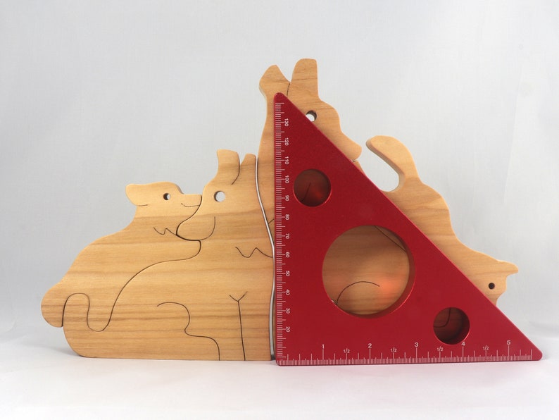 Wooden Wolf Family Stacking Puzzle is handmade from hardwood and finished with mineral oil, beeswax, and carnauba wax. Freestanding interlocking wolf family puzzle pieces shown assembled. Approximate size 10.5 inches long by 6.7 inches high by 3/4 inch thick. Handmade in Tallahassee, Florida, USA.