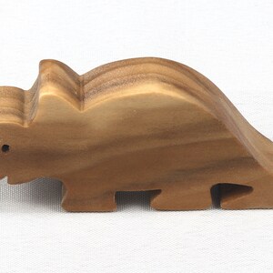 This small wooden triceratops dinosaur toy is crafted from high-quality hardwood and hand-finished. It is a delightful plaything for young children and appeals to many adults.