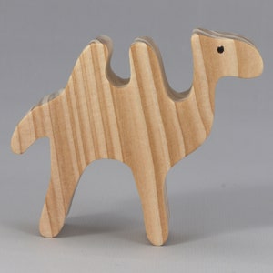 May include: A wooden camel toy with a light brown color and a striped pattern. The camel has two humps and a long neck.