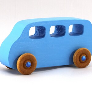 A Handmade wood toy mini van hand-painted baby blue with metallic sapphire blue trim and wheels finished with nonmarring amber shellac from my Play Pall Collection.