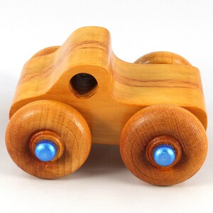 Wood Toy Monster Truck Handmade Form Hardwood and Finished With Amber Shellac With Metallic Saphire Blue Trim.