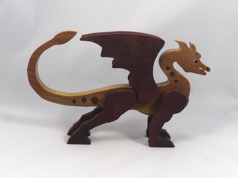 Handmade wooden dragon figurine made from contrasting hardwoods with a light natural wood body and head paired with rich dark reddish-brown wings, legs, and horns.