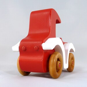Handmade wooden toy car, vintage style red Model T Coupe by Odin's Toy Factory. Two-tone red and white acrylic paint with spoked wooden wheels finished in amber shellac. Approximate dimensions: 5 inches long, 4 inches high, 2.5 inches wide. Part of Bad Bob’s Custom Motors Collection. Crafted from natural wood using traditional woodworking tools. Handmade in Tallahassee, Florida, USA.